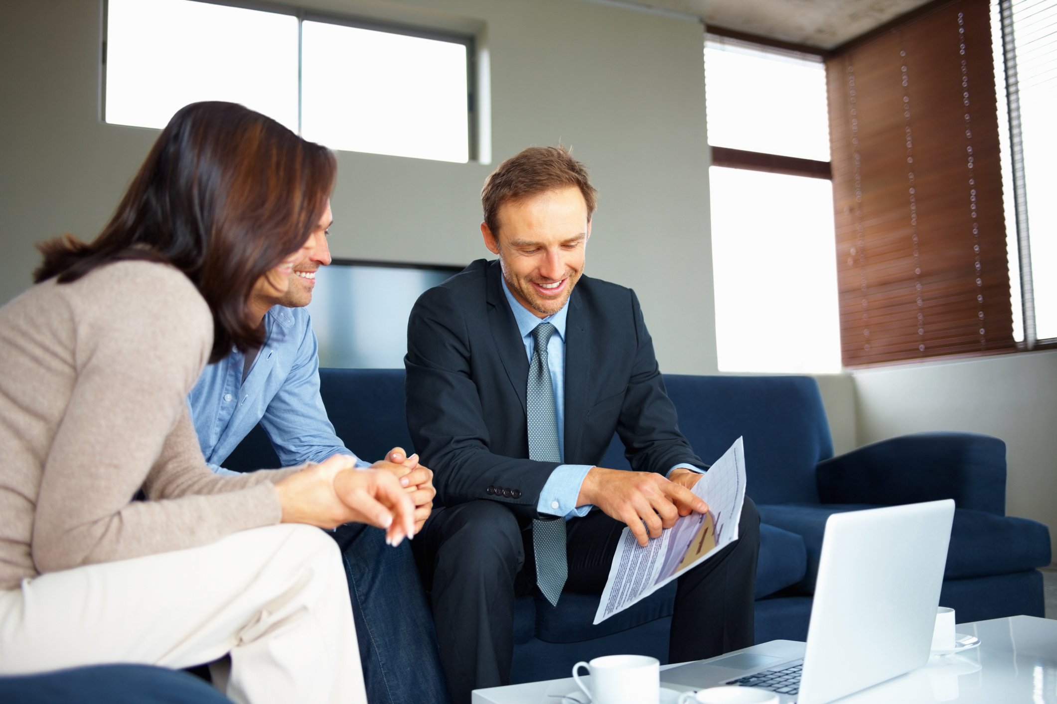 Three people reviewing financial documents.