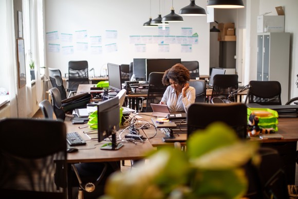 Office worker surrounded by computers.