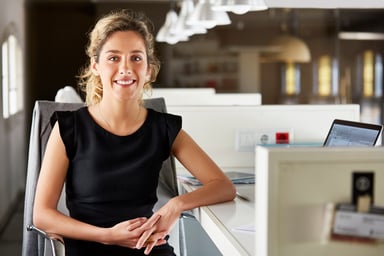 Smiling woman at desk_GettyImages-682897827