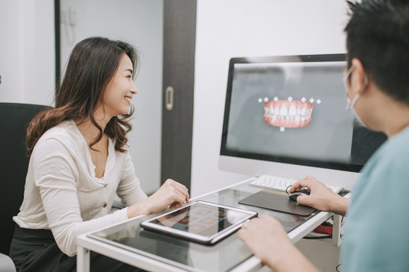 Patient looking at computer screen which includes their smile consultation.