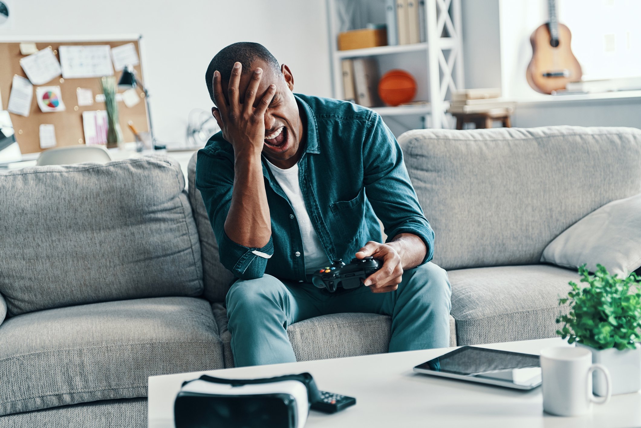 Video gamer at sofa with head in hand