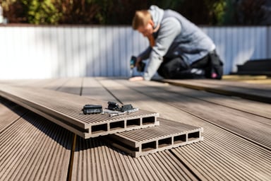 A person installing composite decking boards.