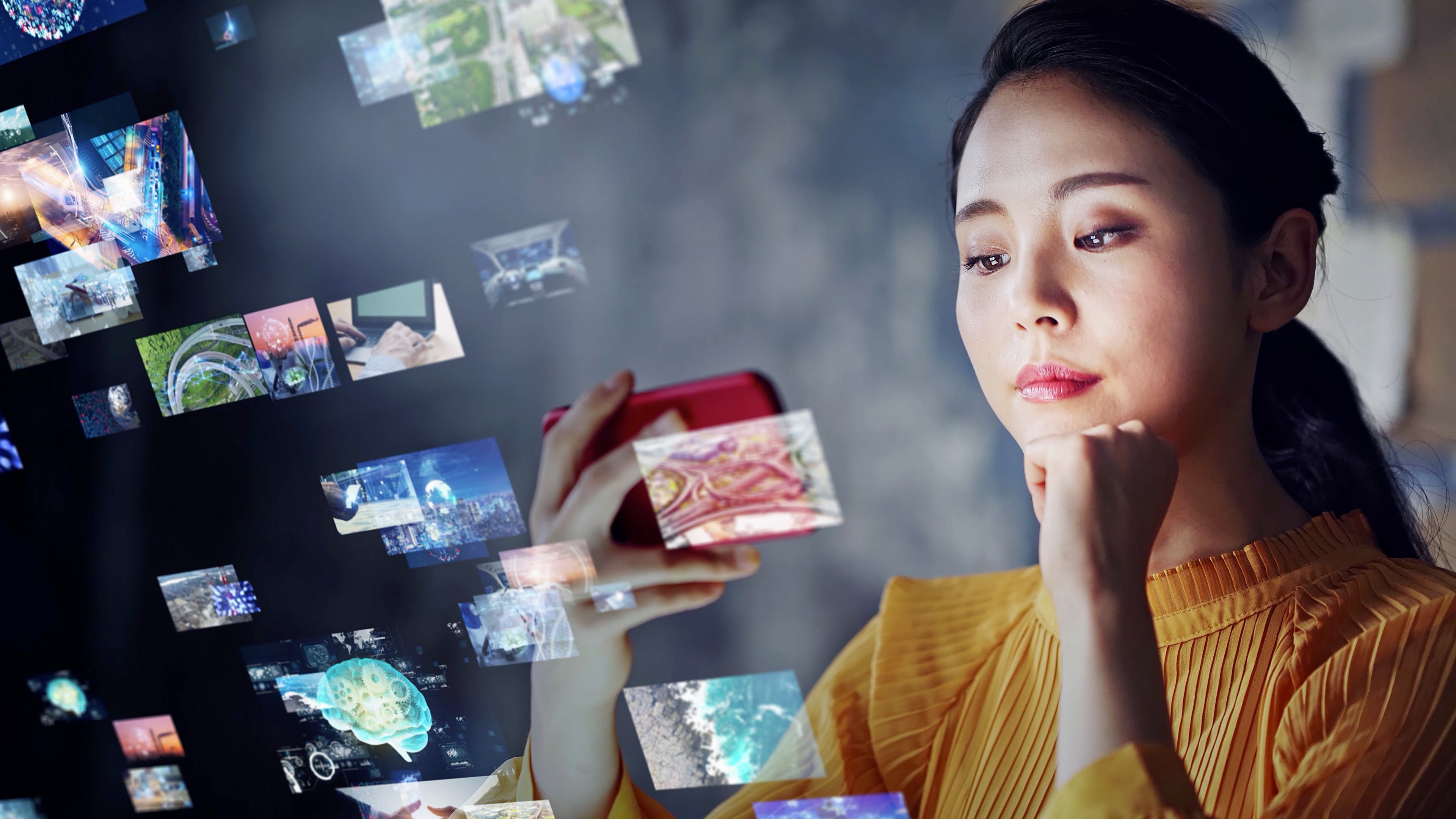 Young woman holds up phone and reflections of her  screen fly around it  in the air. 