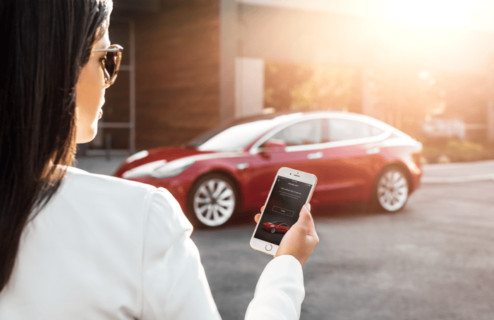 A person unlocking a Tesla with the Tesla mobile app.