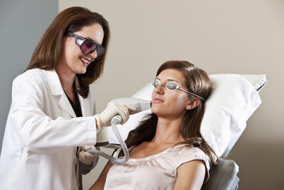 A technician providing laser hair removal services to a customer.