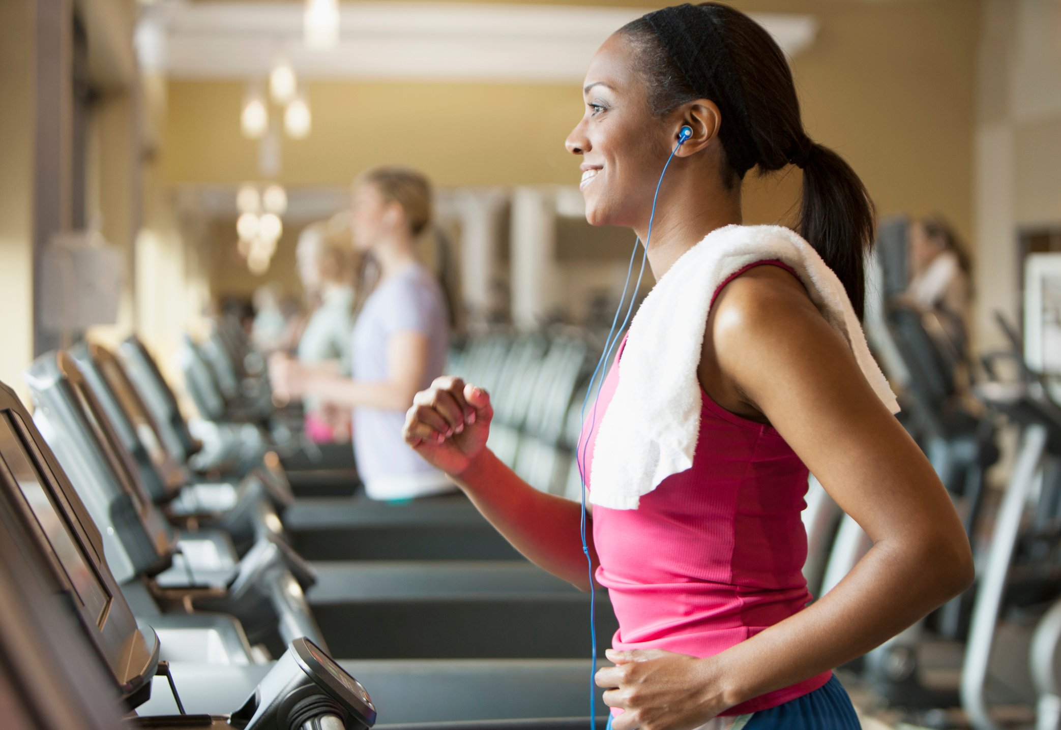person running on treadmill with ear buds in