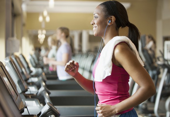 person running on treadmill with ear buds in