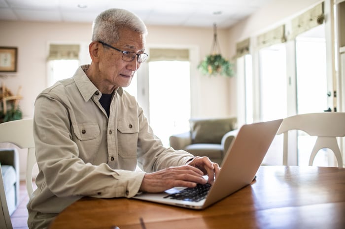 Person typing on a laptop on a table.