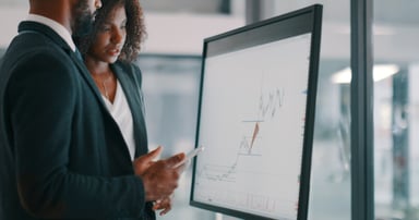 Two people looking at a stock chart.