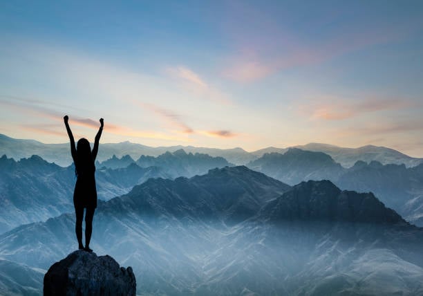 Picture of person celebrating on top of a summit
