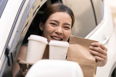 A woman going through a drive-thru restaurant