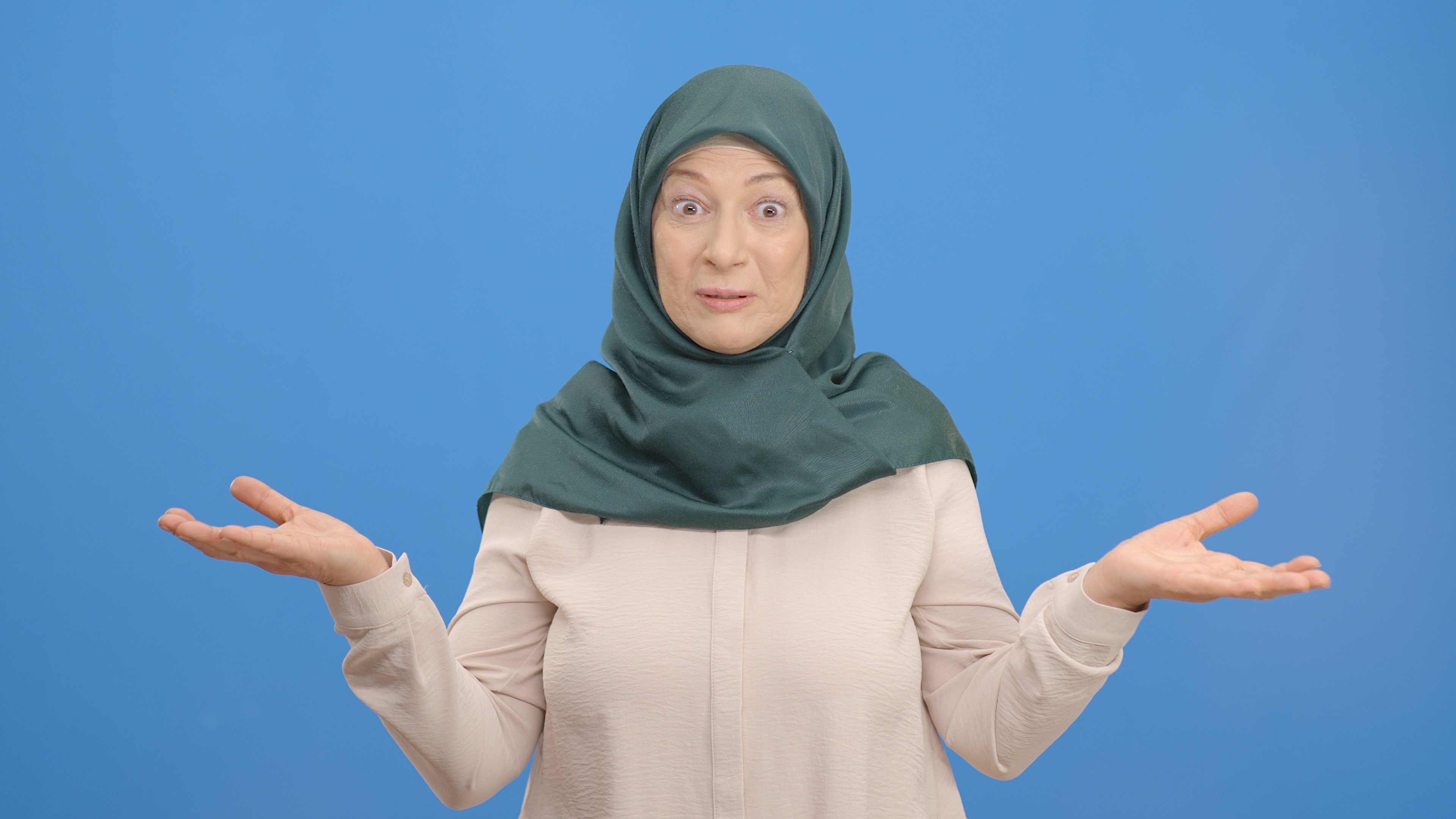 A person with a confused look on their face is gesturing with palms up, that they don't know. 