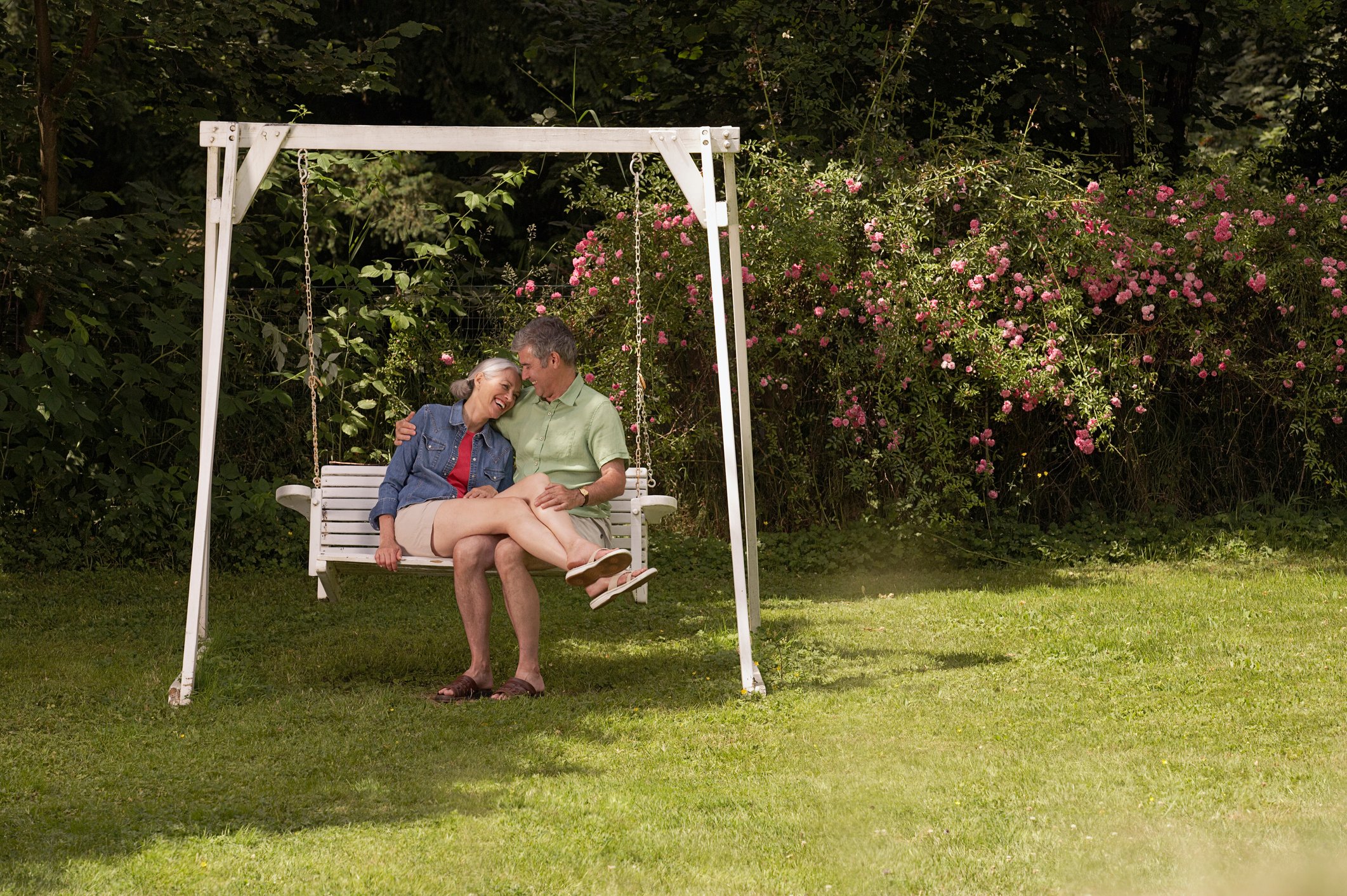 A couple sitting on a swing.