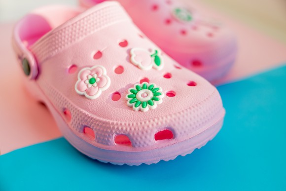 A pink pair of foam clogs for children.