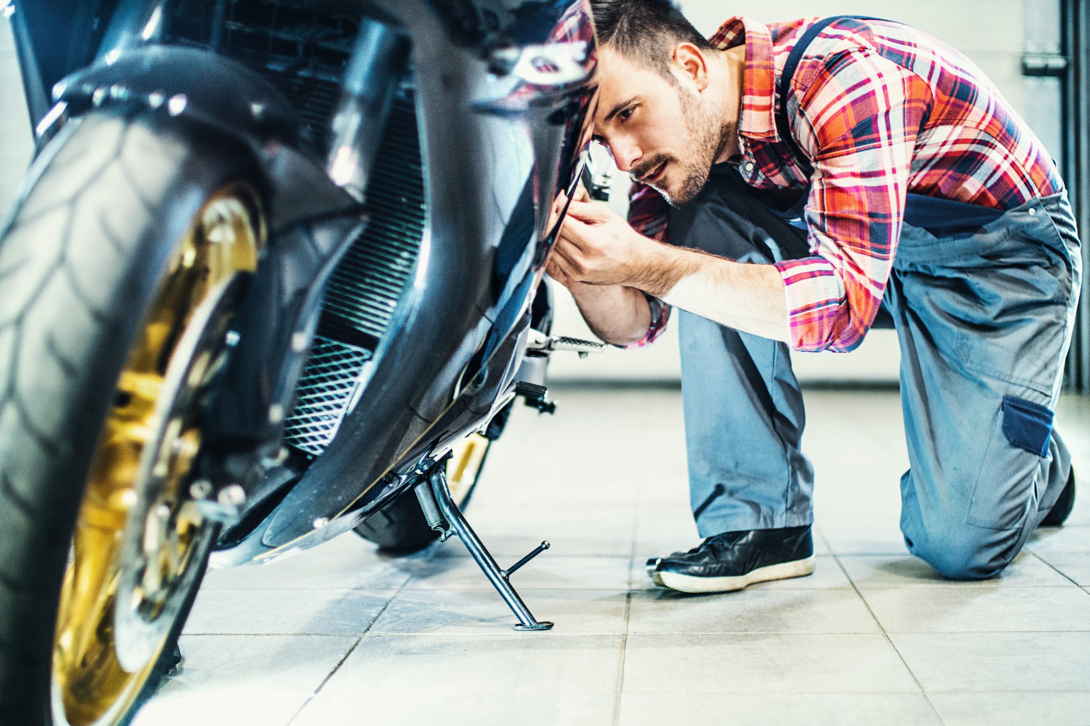 A mechanic fixing a motorcycle.