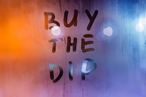 "Buy the dip" written on a foggy window.