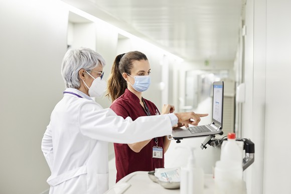 Doctor and nurse in a hospital both wearing masks. 