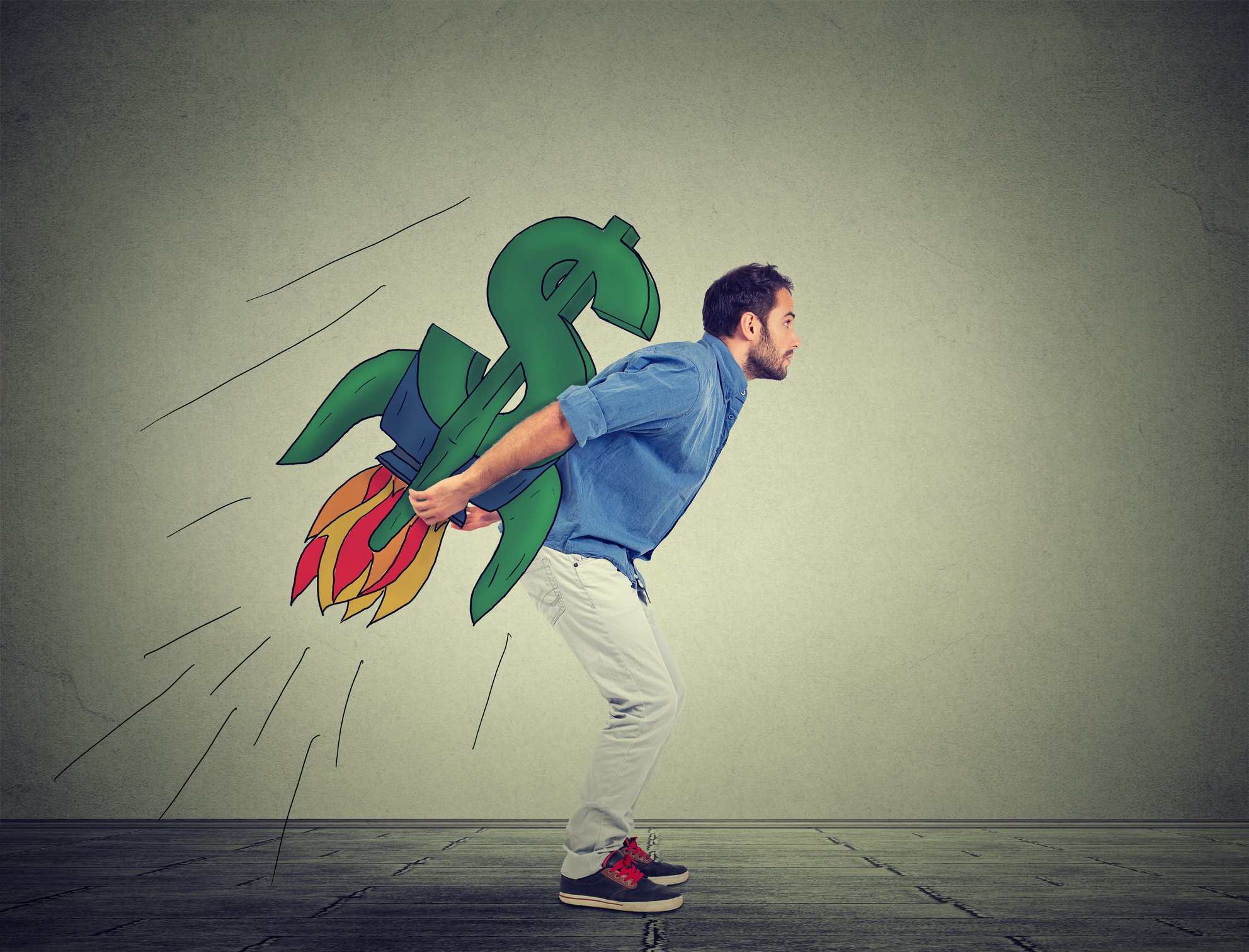 A person holding on to a money sign designed rocket.