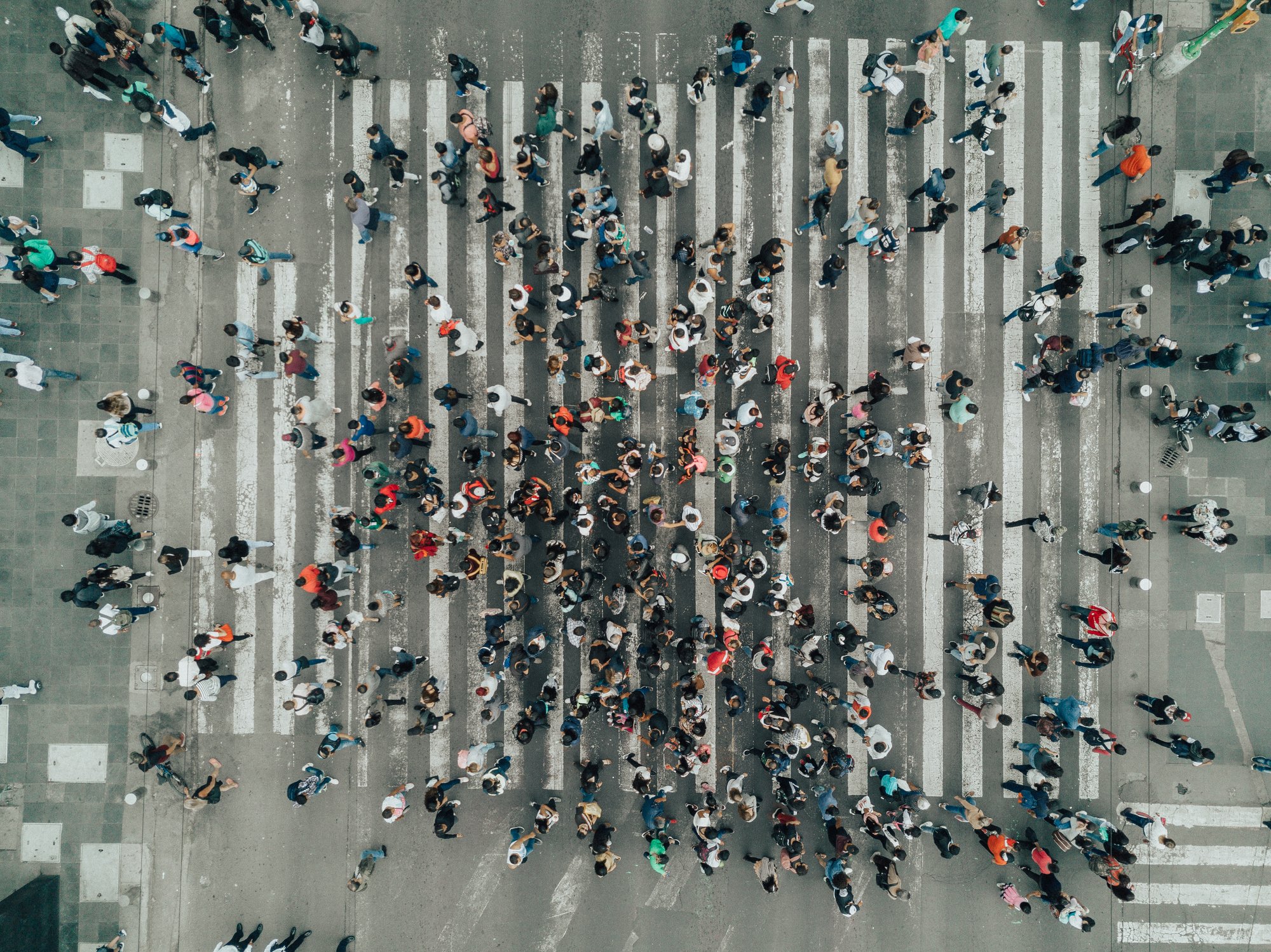 Aerial view of a crosswalk with lots of people walking.