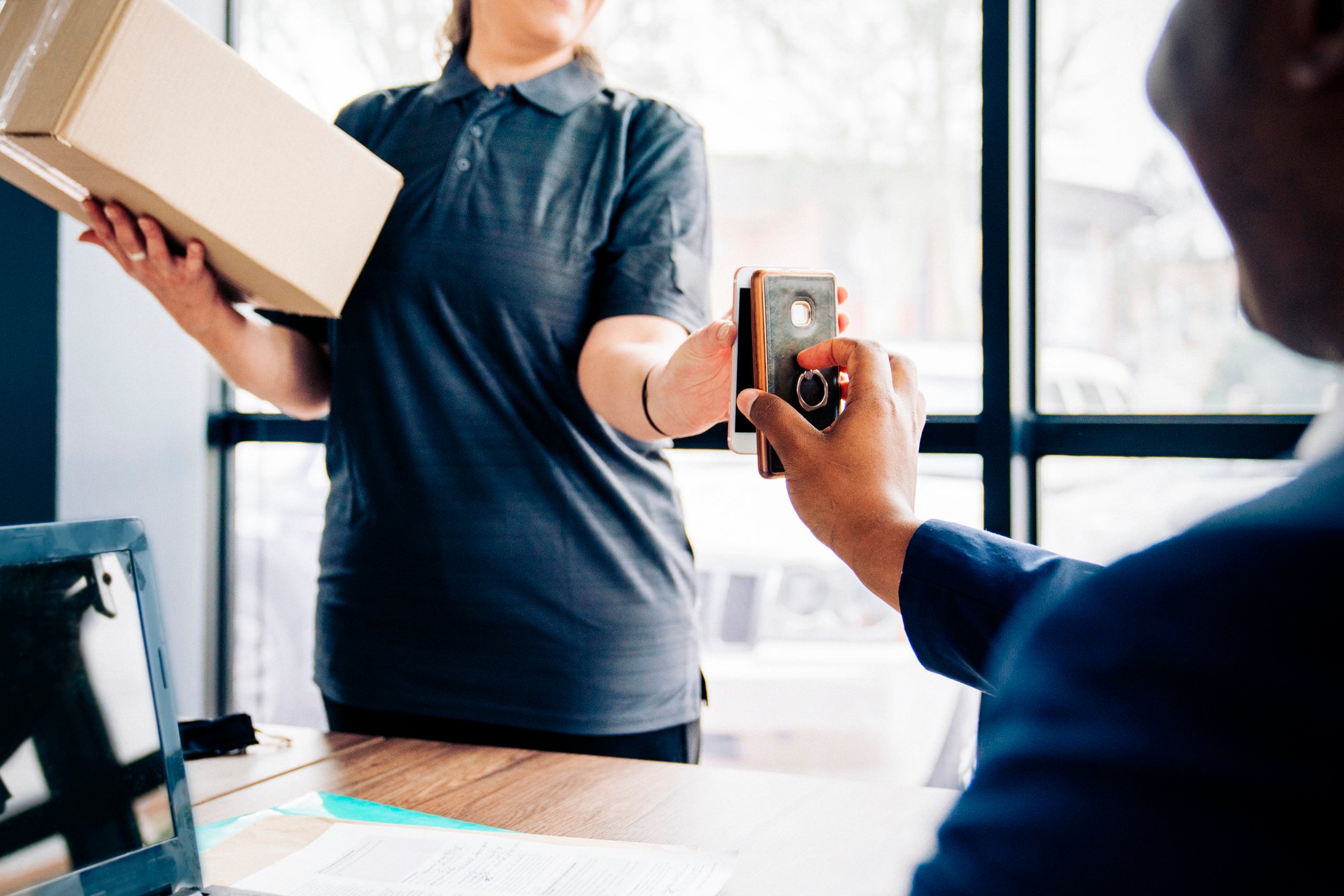 Two people engage in a financial transaction over smartphones.