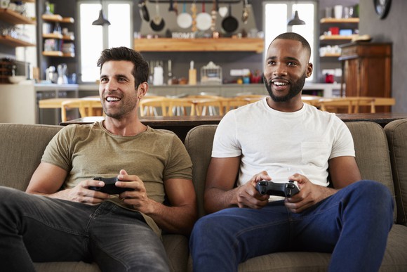 Two people on couch playing video games.