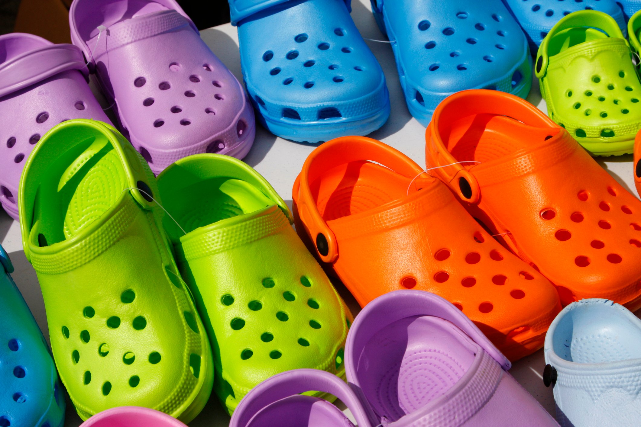 Colorful plastic clogs lined up in three rows.