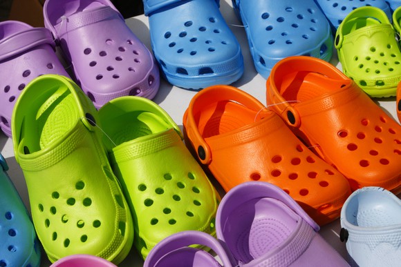 Colorful plastic clogs lined up in three rows.
