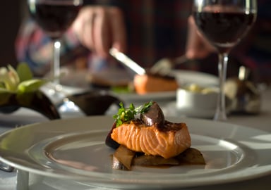 Salmon plate on a white table cloth dining table
