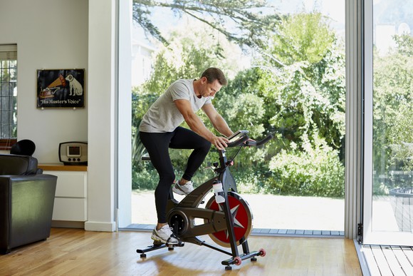 Person at home on exercise bike.