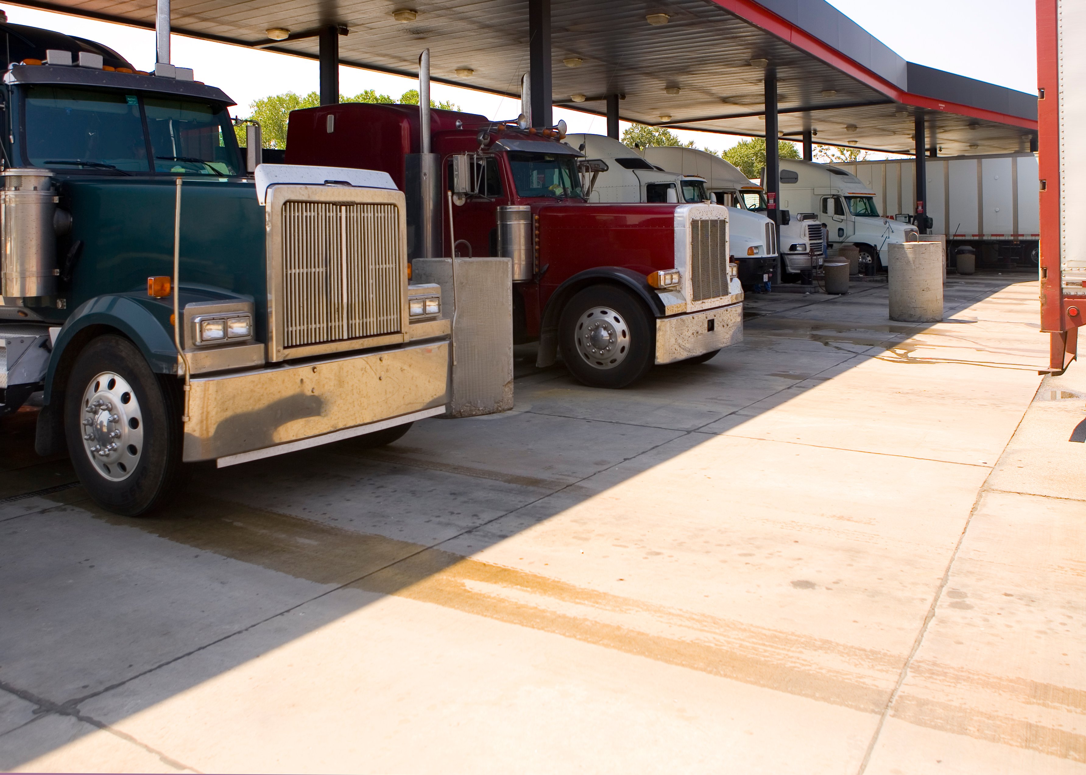 Line of semi trucks fueling up at a gas station