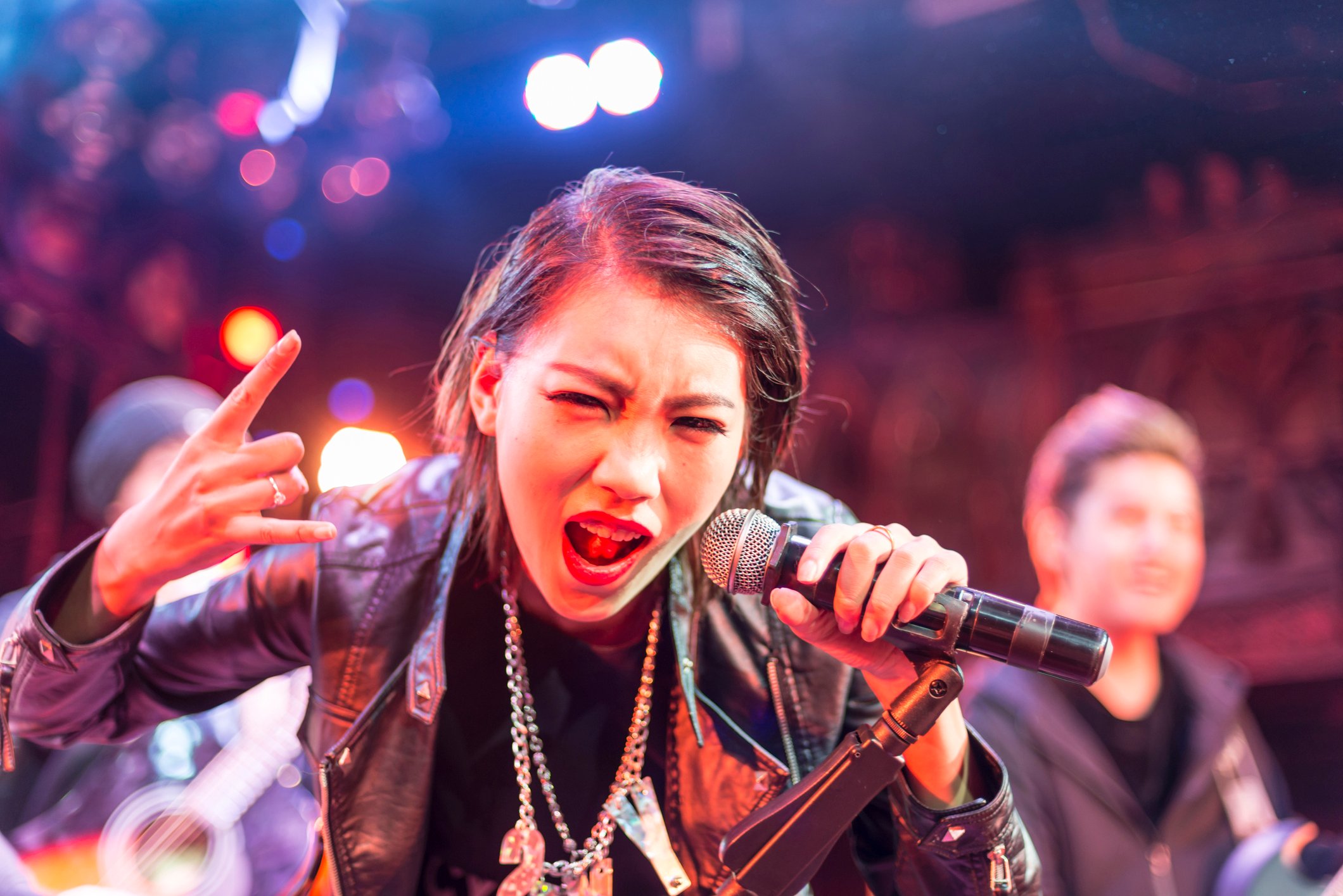 A lead vocalist sings during a live performance.