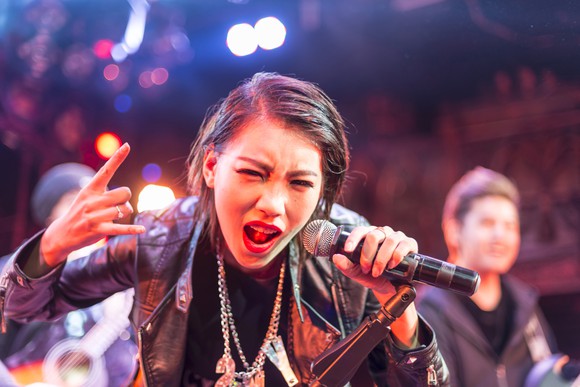 A lead vocalist sings during a live performance.
