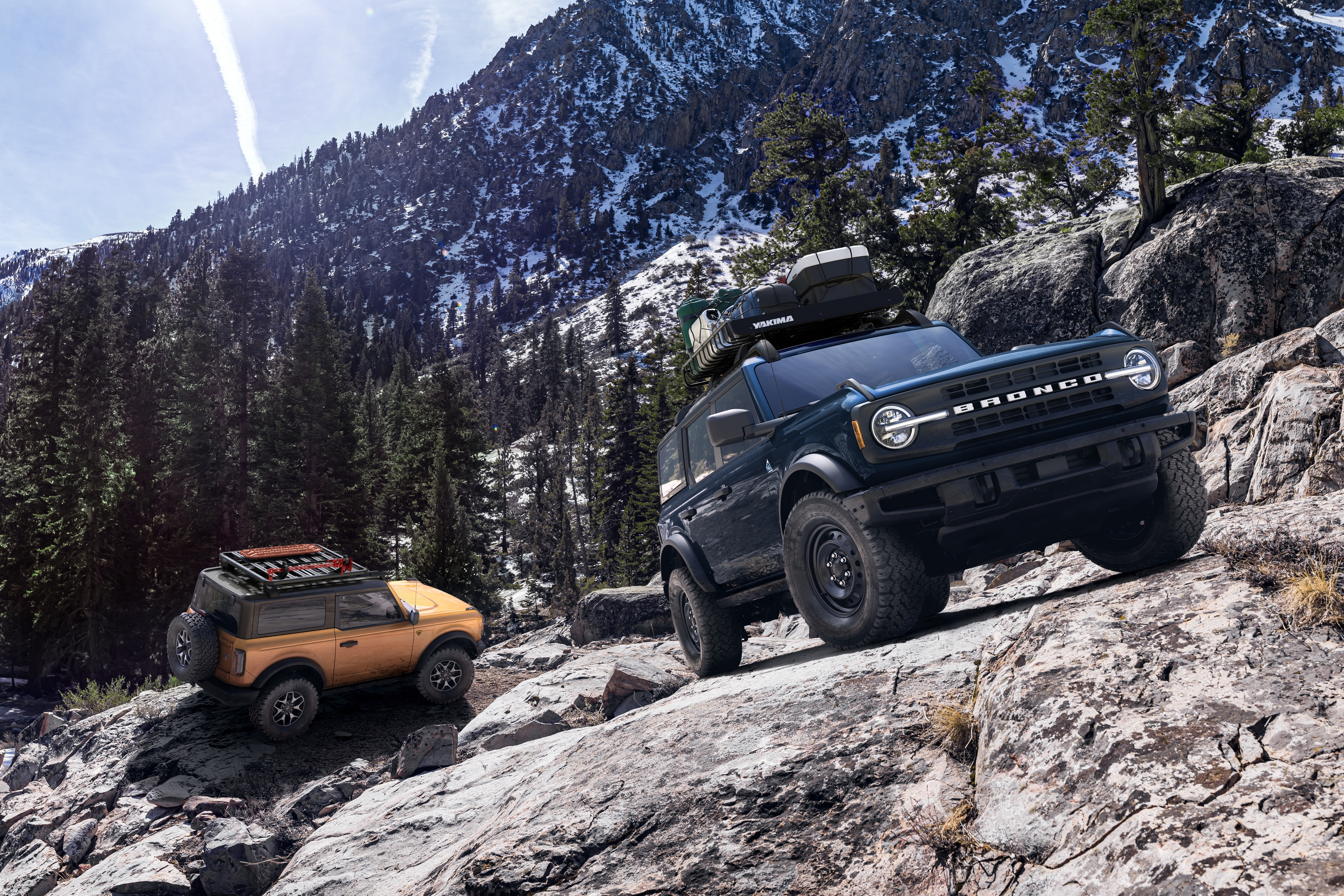A pair of Ford Broncos on a rugged mountain.