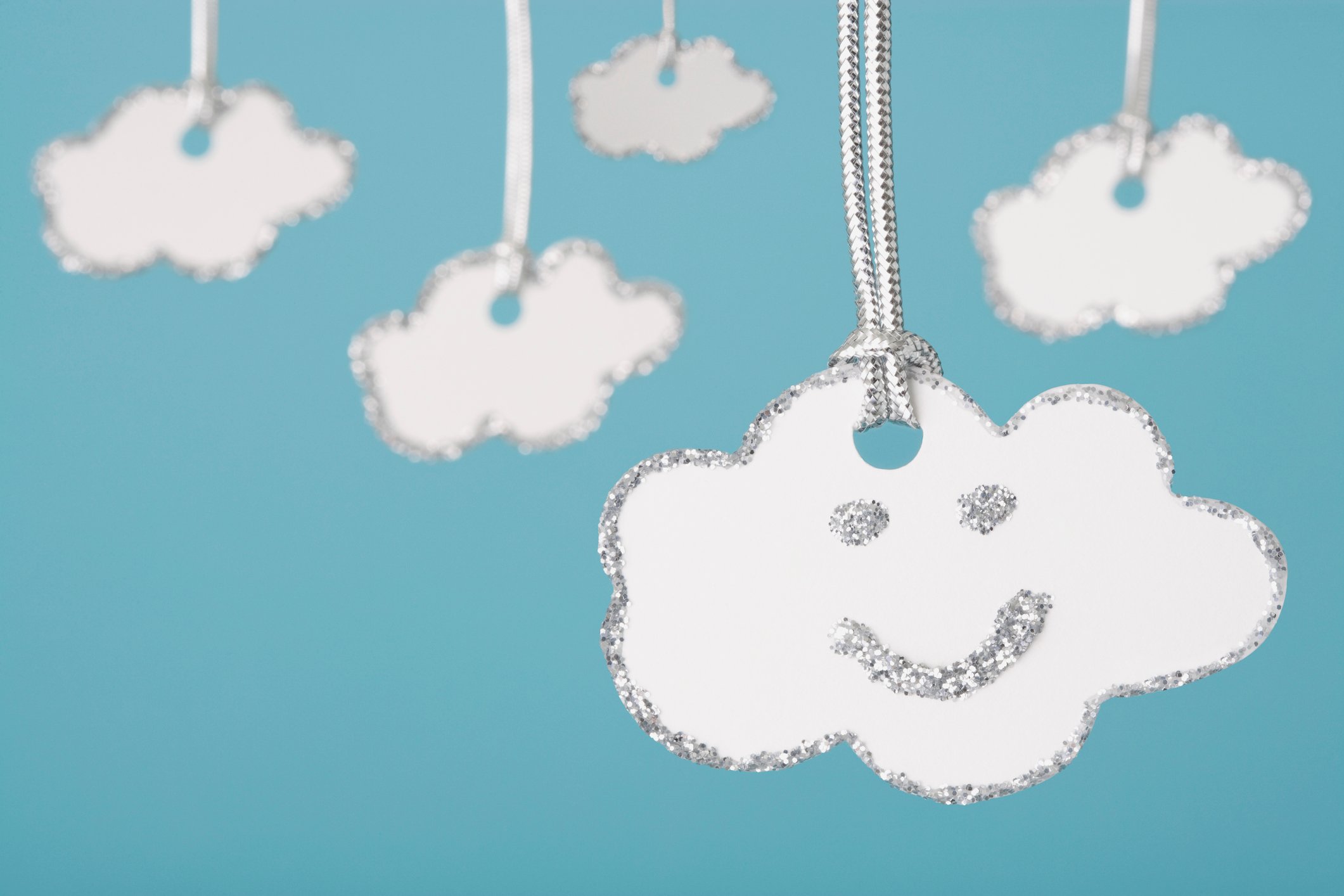 Cloud shaped keychain with smiley face on it. 