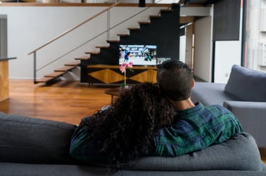 couple watches TV from a couch