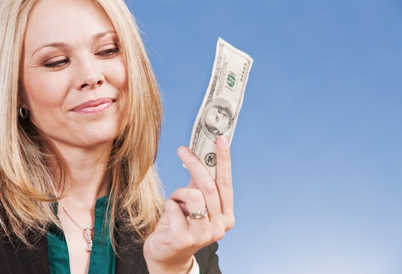 Smiling person holding cash.