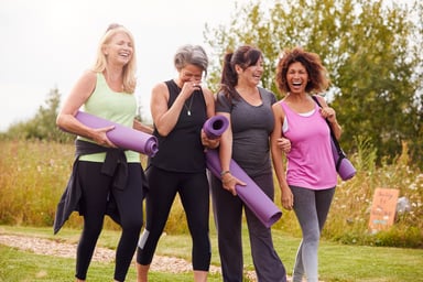 Four women carrying yoga mats