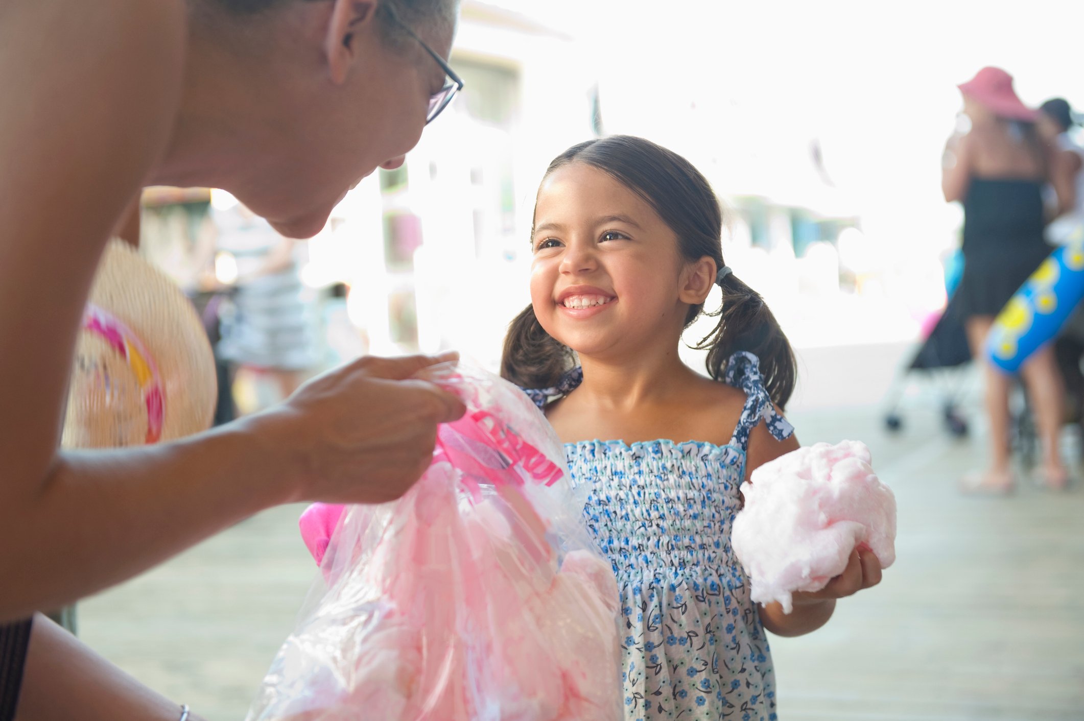 A child and adult smiling over cotton candy.