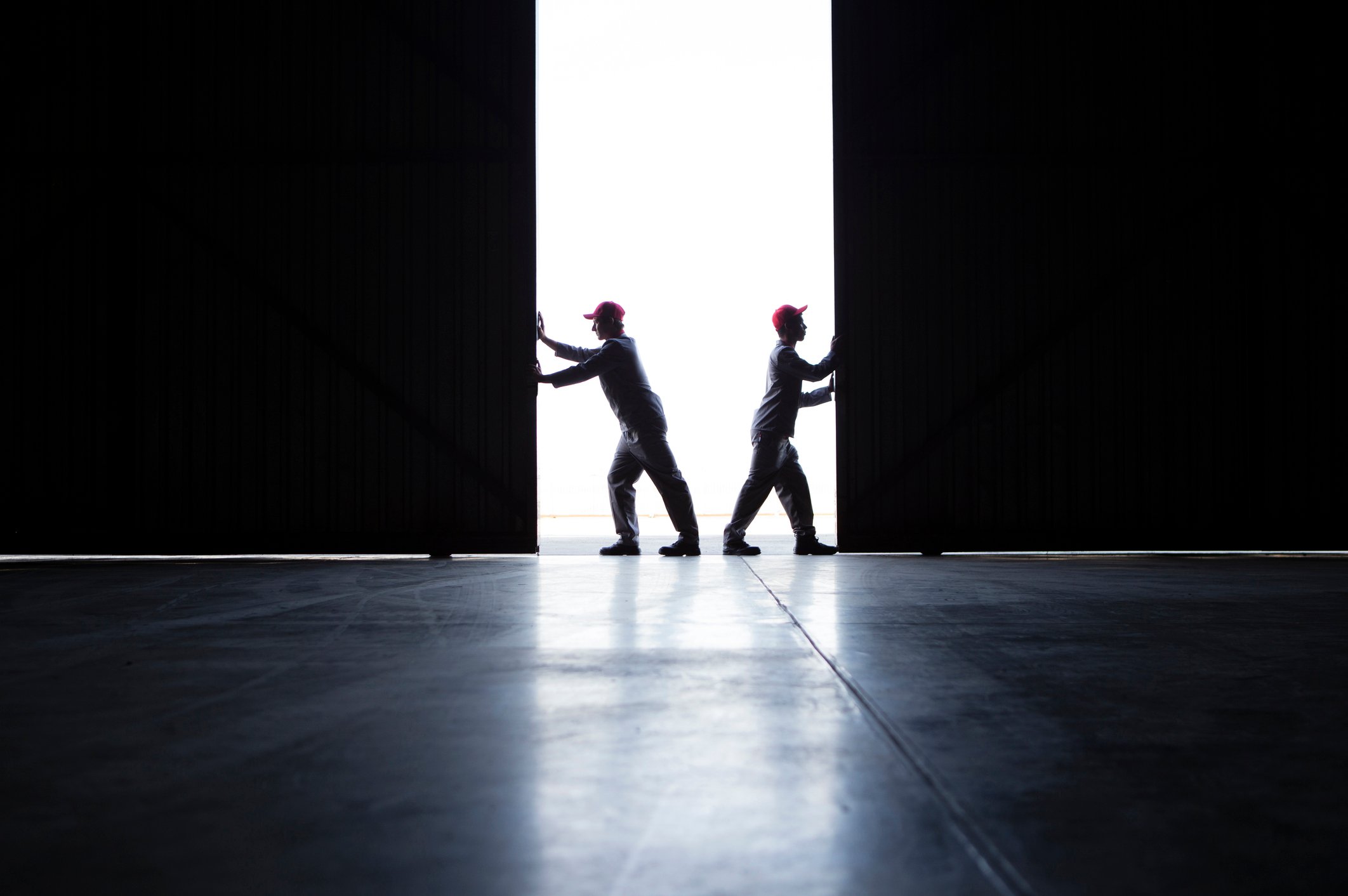 two people opening industrial real estate doors