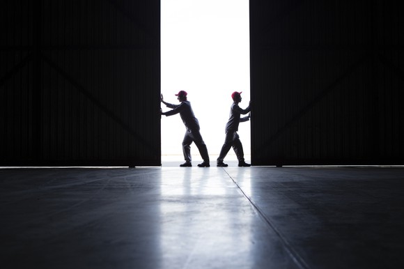 two people opening industrial real estate doors