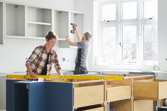 Two people renovating a kitchen.