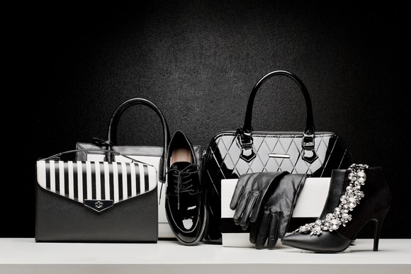 luxury handbags, shoes, and black gloves on display.