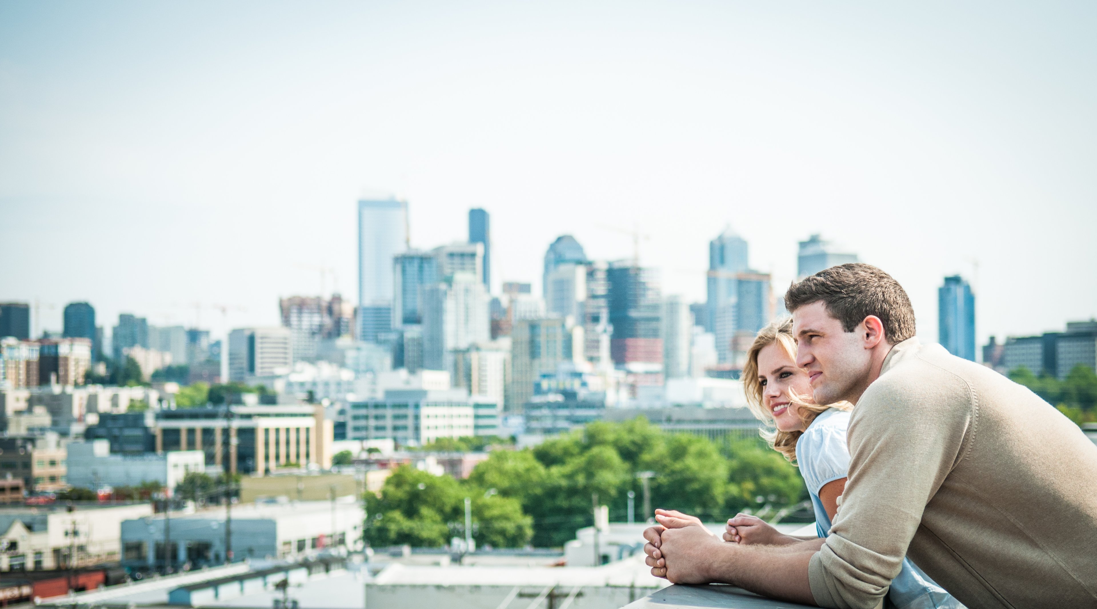 2 people on roof deck overlooking city