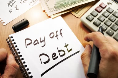 Pay off debt scrawled on a notepad
