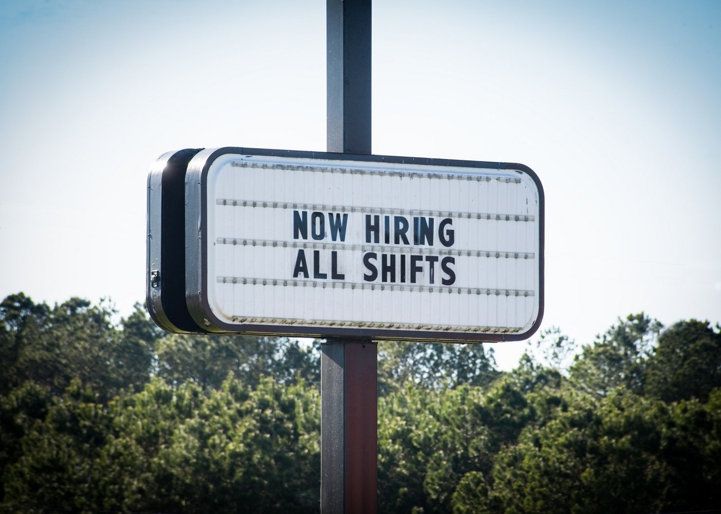 Sign that reads now hiring all shifts.