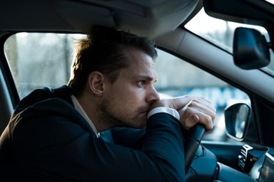 A distressed person sitting in a car.
