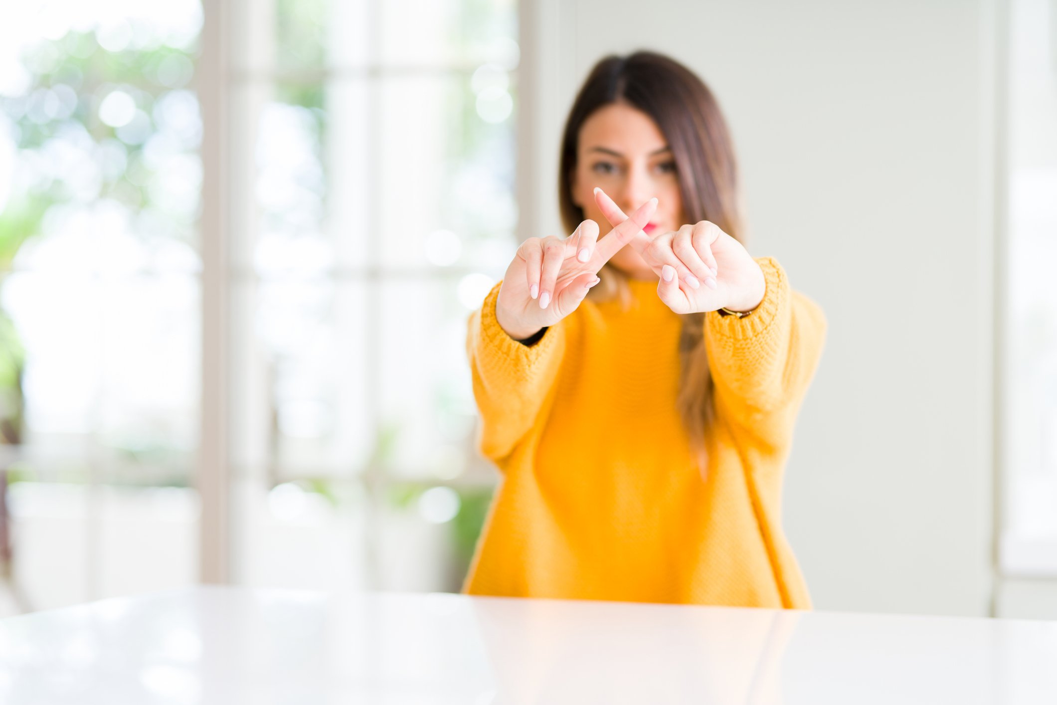 A person holding fingers together to form an "X".