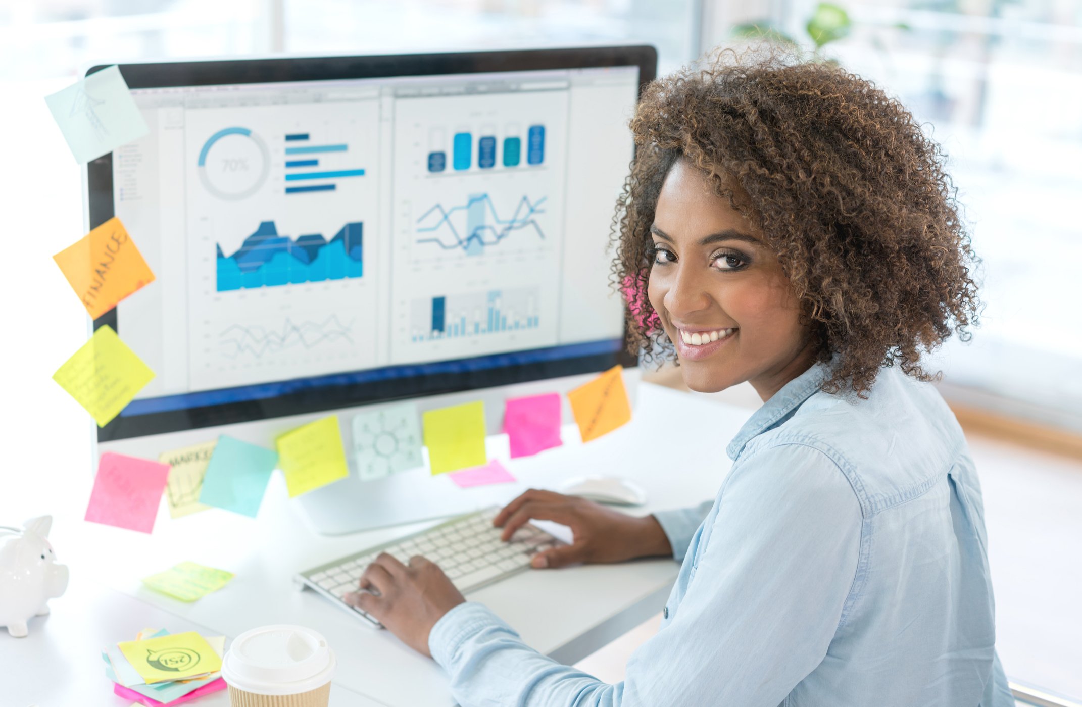 Businesswoman analyzing various charts and graphs on her computer.