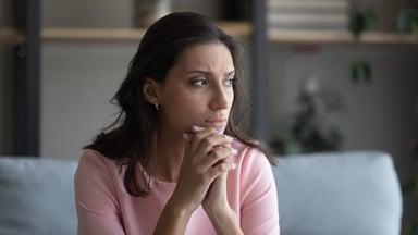person with clasped hands feeling worried