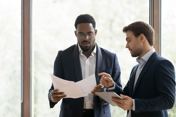 Two people having a discussion over some documents.